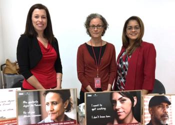 Portrait of Dr. Lorraine Reitzel, Dr. Isabel Martinez Leal, and Virmarie Correa-Fernandez with TTTF printed collateral spread across a table in the foreground.