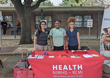 HEALTH RCMI table at event with (left to right) Virmarie Correa-Fernandez, Shalan Washington and Evan Coleman.