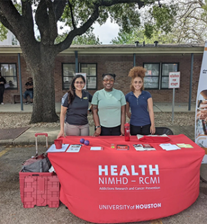 HEALTH RCMI table at event with (left to right) Virmarie Correa-Fernandez, Shalan Washington and Evan Coleman.