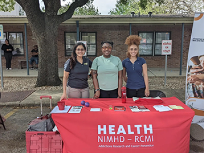 HEALTH RCMI table at event with (left to right) Virmarie Correa-Fernandez, Shalan Washington and Evan Coleman.